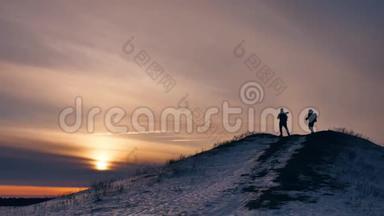 人们冬天跳跃剪影，喜雪阳光。 一群游客走在夕阳的剪影之上